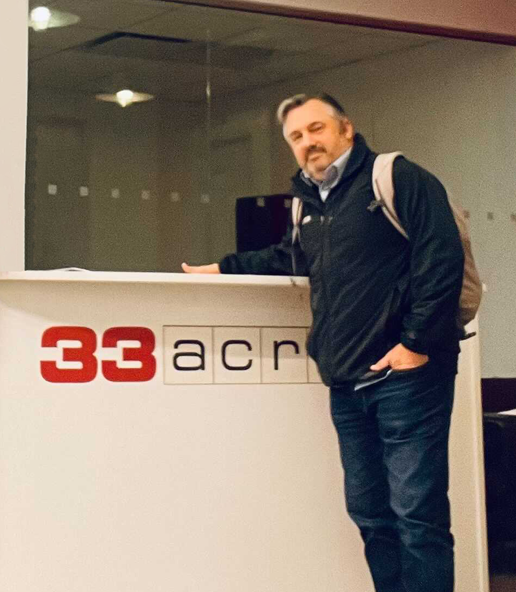 John stood in front of 33Across reception desk at the New York office